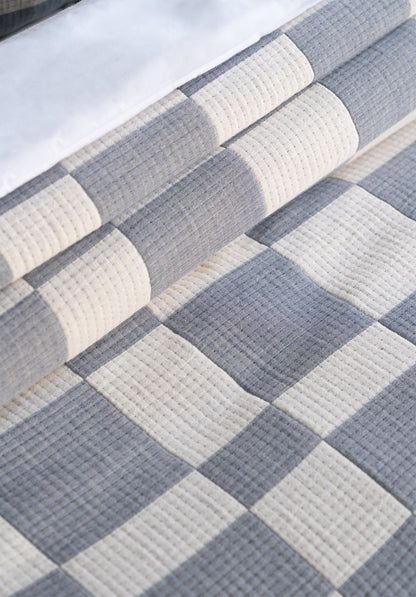 Close-up of a quilt with a checkered pattern in blue and white.
